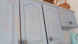 A kitchen with white cabinets, starfish handles, and a teal kettle. - Apartment 'Memories' with Balcony, Wi-Fi and Air Conditioning (Palekastro)