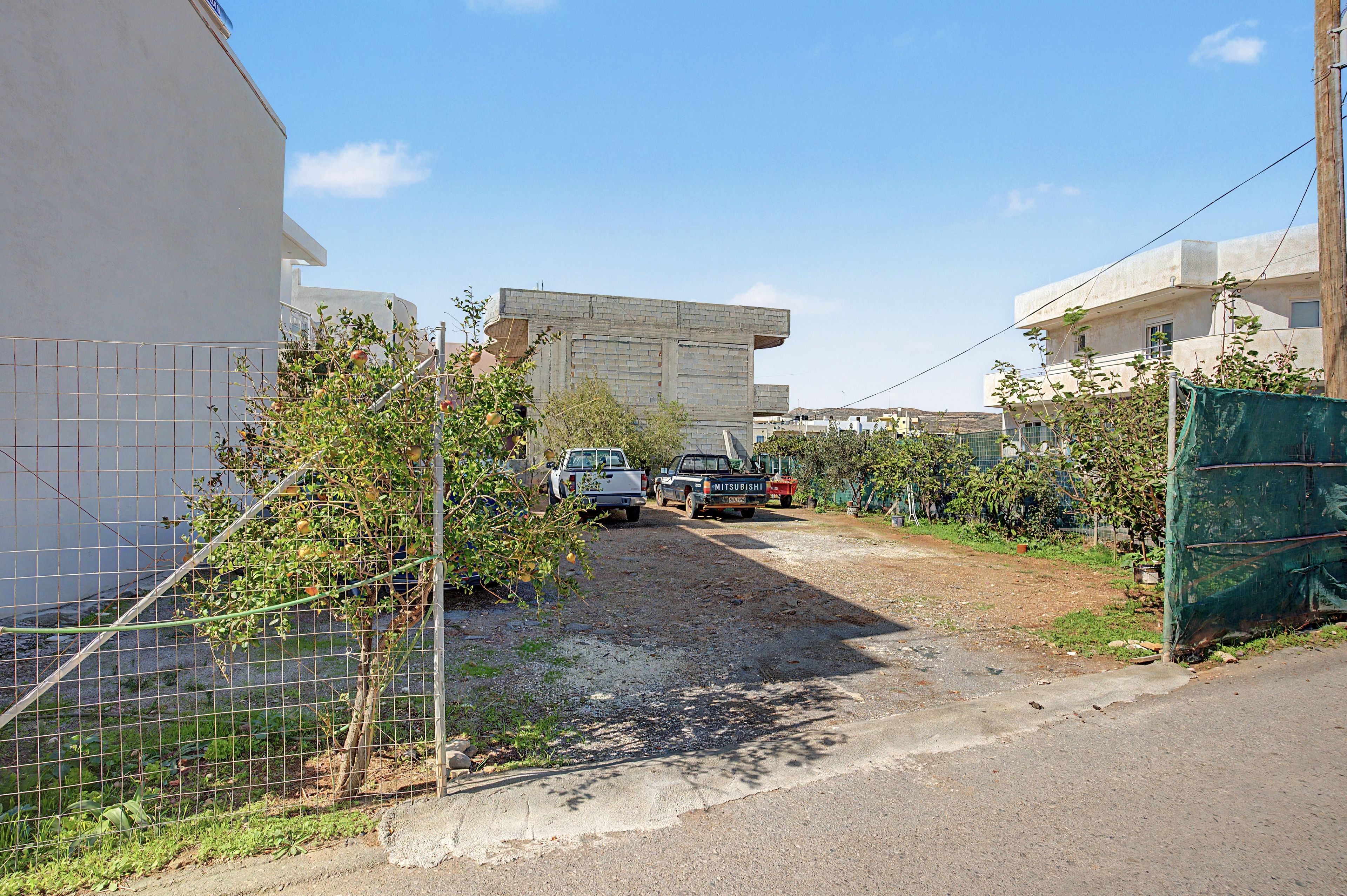Una estrecha vía pavimentada bordeada por edificios residenciales y vegetación.