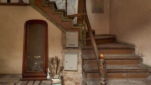 Una escalera con barandillas de madera y suelo de baldosas.
