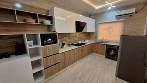 Eine moderne Küche mit eingebauten Geräten, Holzschränken und einer Mikrowelle.