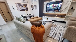 Ein modernes Wohnzimmer mit Sofa, Couchtisch und Fernseher.