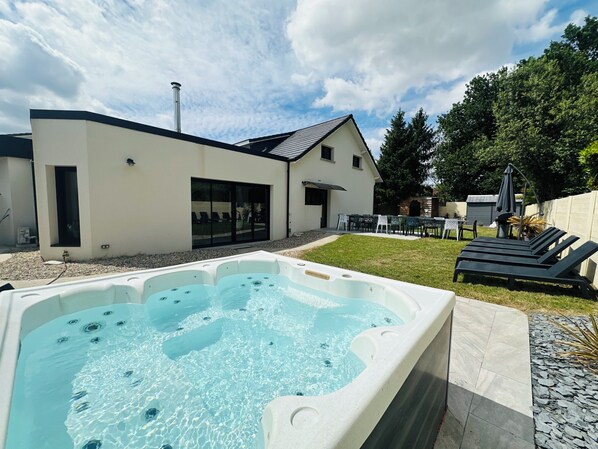 A modern house with a hot tub, outdoor seating, and a patio area. - Large 10-bedroom house - Jacuzzi - Garden - Near Bordeaux & Tram (Villenave-d'Ornon)