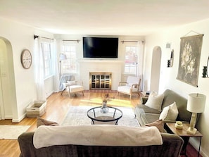 Ein Wohnzimmer mit Kamin, Flachbildfernseher und einer Couch.