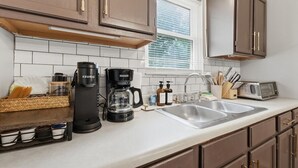 A kitchen with a coffee maker, a toaster, and a sink. - Secluded Cabin w/ Hot Tub & Stunning Mountain (Sevierville)