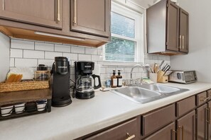 A kitchen with a coffee maker, a toaster, and a sink. - Secluded Cabin w/ Hot Tub & Stunning Mountain (Sevierville)
