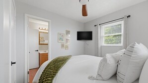 A bedroom with a bed, a ceiling fan, a television, and a window with blinds. - Secluded Cabin w/ Hot Tub & Stunning Mountain (Sevierville)