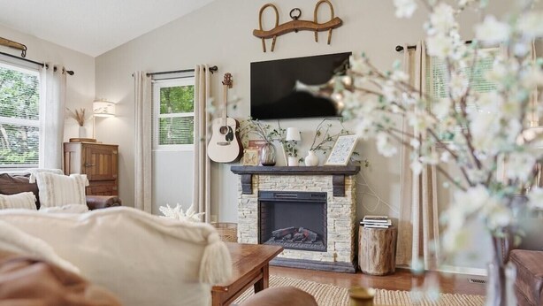 A cozy living room with a fireplace, a television mounted above it, and a comfortable seating area with a sofa and a coffee table. - Secluded Cabin w/ Hot Tub & Stunning Mountain (Sevierville)