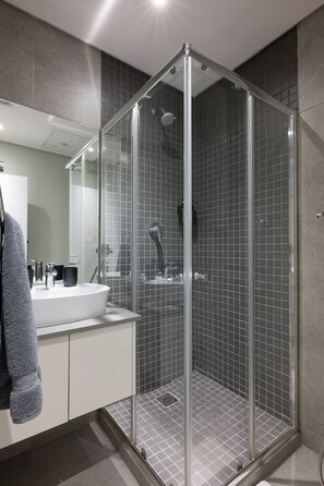 A modern bathroom with a glass-enclosed shower, a white sink, and a large mirror. - Slick Garden Gem 300 on Florida RD (Morningside, KwaZulu-Natal)