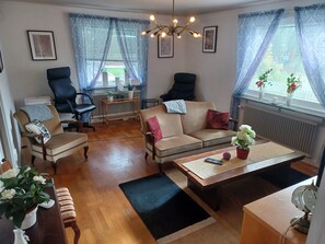 A living room with a sofa, chairs, a coffee table, and a dining table. - Cosy HAPPY PLACE Experience the kingdom of Crystal in the Swedish Smaland. (Boda glasbruk)