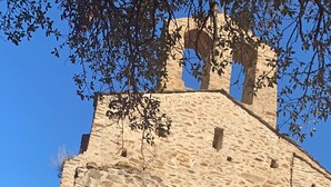 A stone building with a wooden door and a bell tower. - The Cocon Lou Jaïa (Corbère)