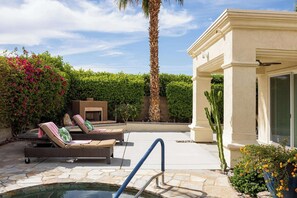 An outdoor pool area with lounge chairs, a palm tree, and a cactus. - Casa Veranda Puerta Azul Pool Retreat (La Quinta)