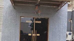 A reception area with a glass door, a 'No Smoking' sign, and a 'Reception' sign. - The Oliver Lofts Hotels (Abuja)