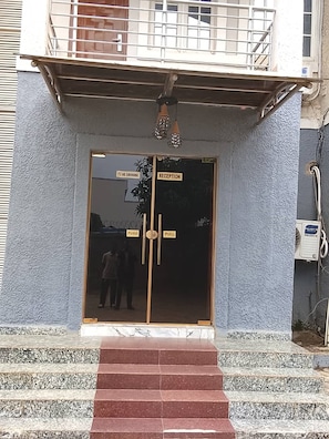 A reception area with a glass door, a 'No Smoking' sign, and a 'Reception' sign. - The Oliver Lofts Hotels (Abuja)