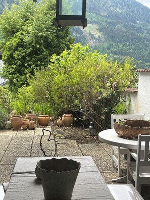 A patio with a table, chairs, and potted plants. - Chalet to feel good Golf, ski, mountains, lake (Goldegg)