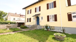 A two-story building with a yellow facade, brown shutters, and a blue door. - Liboria vacation apartment Starnberg with balcony for 6 persons (Starnberg)
