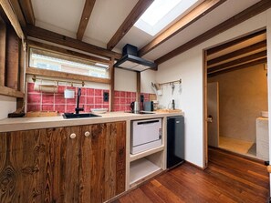 A compact kitchen with a wooden island, a built-in dishwasher, and a skylight. - Casa Bohèm - Cosy beach studio for two (Zandvoort)