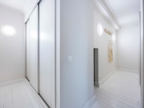 Una habitación moderna y minimalista, con paredes blancas, piso de madera y una puerta corredera.