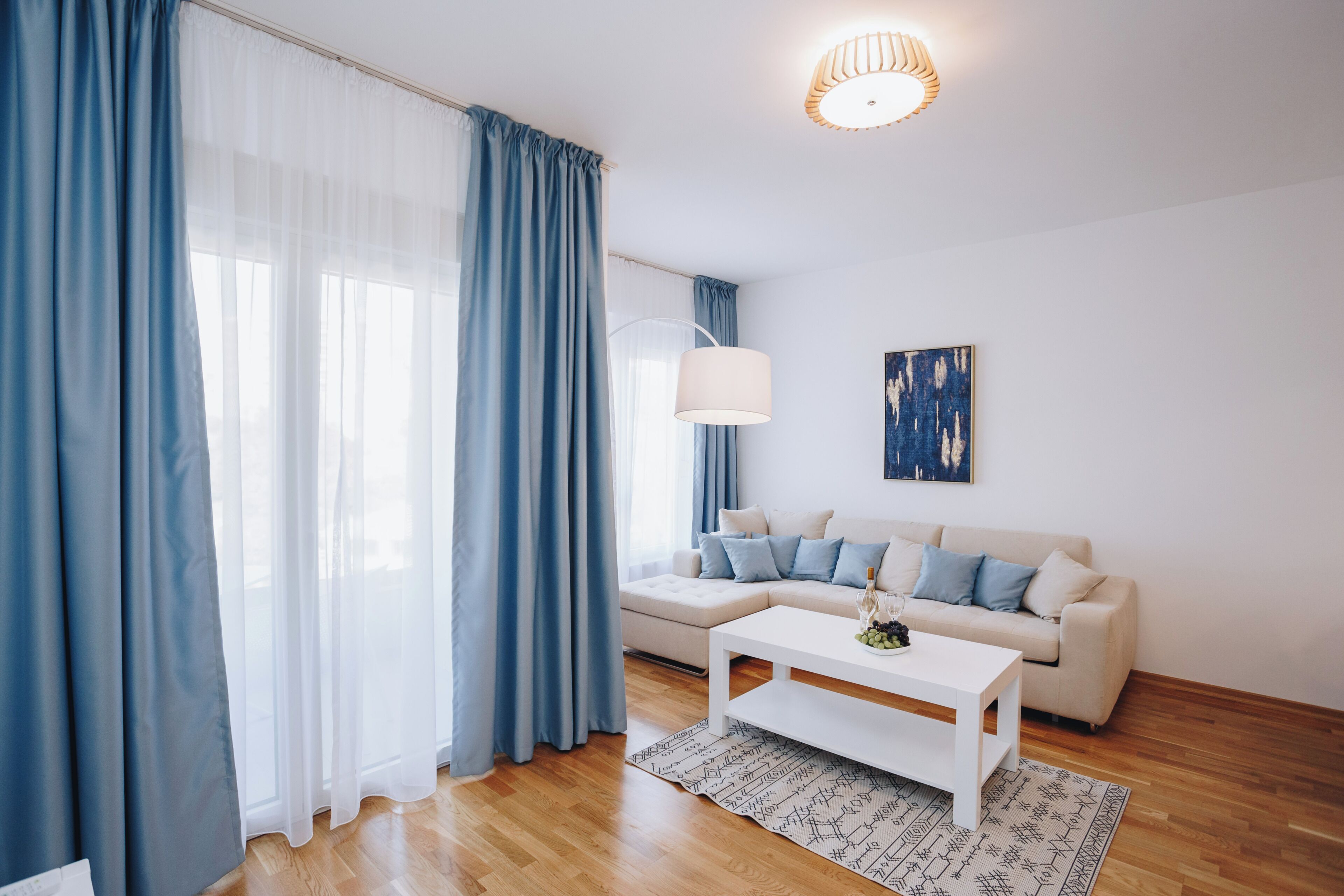 A modern living room with a sofa, a coffee table, and a lamp.
