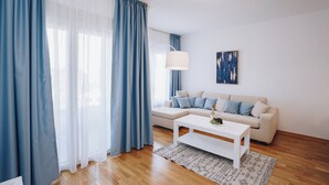 Un salon moderne avec un canapé, une table basse et une lampe.