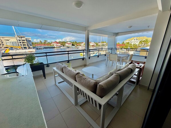 En balkon med sofa, spisebord og stole.