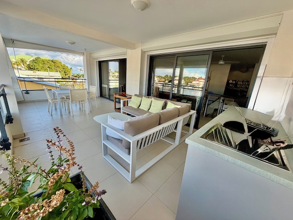 A modern living room with a sofa, a dining area, and a kitchen area. - The two suites at the Marina (Saint francois)