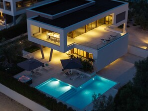 A modern two-story house with a swimming pool, outdoor seating, and a patio area. - Luxury Villa Old Olive I - heated private pool, jacuzzi, sauna and more, for 12 persons. (Vodnjan)