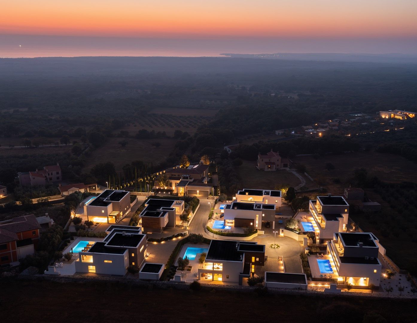 Un quartier résidentiel avec des maisons modernes, une piscine et une vue sur le paysage.