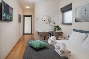 A hotel room with a bed, a desk, a chair, a green pillow, and towels. - Luxury Villa Old Olive I - heated private pool, jacuzzi, sauna and more, for 12 persons. (Vodnjan)
