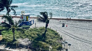Una torretta per bagnini, spiaggia e palme.