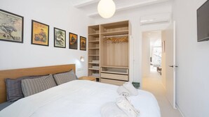 Une chambre d’hôtel avec un grand lit, une armoire et un téléviseur.