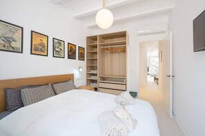 Ein Hotelzimmer mit einem großen Bett, einem Kleiderschrank und einem Fernseher.