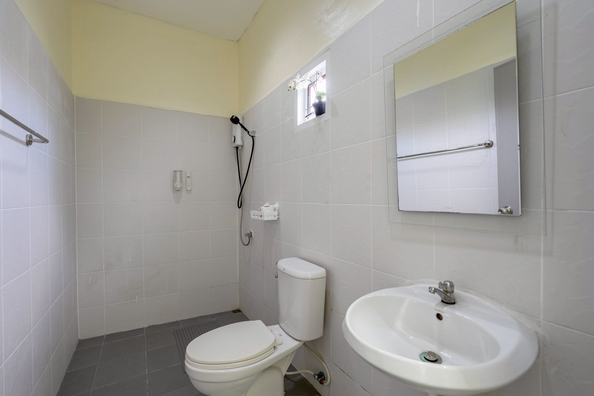 Un baño pequeño y limpio con inodoro, lavamanos y espejo.