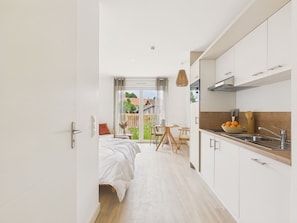 A modern kitchen with white cabinets, a wooden countertop, and a sink. - Pavones – Studio for 3 with shared pool (Biscarrosse)