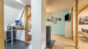 A modern interior with a kitchen area, a seating area with a sofa, and a dining table.