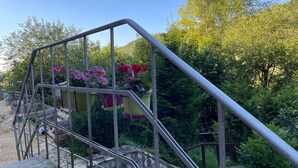 A staircase with metal railings, surrounded by greenery and potted plants.