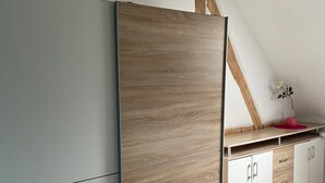 A kitchen with a large refrigerator, wooden cabinets, and a countertop.