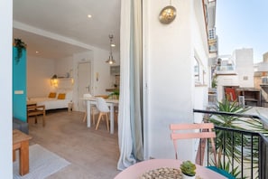 Eine moderne Wohnung mit Essbereich, Wohnzimmer und Balkon mit Pflanzen.