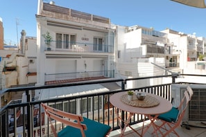 A balcony with a table and chairs, overlooking a residential area with white buildings. - Studio 50m from the Beach | Pedro by Palmera Group (Sitges)