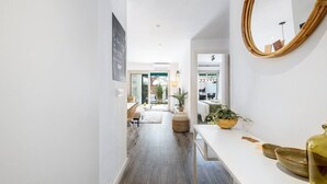 Un intérieur moderne avec un couloir blanc qui mène à une salle à manger et à une chambre.