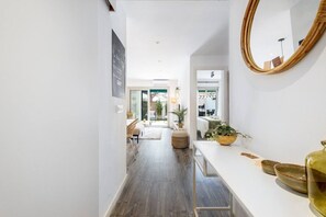 A modern interior with a white hallway leading to a dining area and a bedroom. - Modern Apartment w/ big Patio | Maria by Palmera (Sant Pere de Ribes)