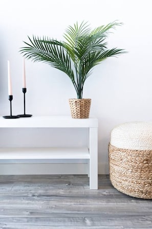 A white console table with a woven basket, two candles, and a potted plant. - Modern Apartment w/ big Patio | Maria by Palmera (Sant Pere de Ribes)
