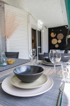 A dining table set with a bowl, plates, glasses, and cutlery. - Modern Apartment w/ big Patio | Maria by Palmera (Sant Pere de Ribes)