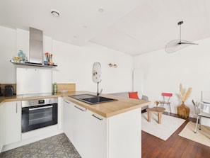 A modern kitchen with a built-in oven, a sink, and a wooden countertop. - House for 5 with garden, close to the beach (Saint-Gilles-Croix-de-Vie)