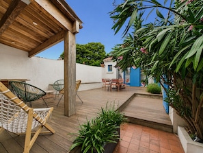 A wooden deck with outdoor furniture, a hanging chair, and potted plants. - House for 5 with garden, close to the beach (Saint-Gilles-Croix-de-Vie)