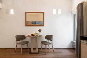 A room with a wooden table, two chairs, a painting, and a window with curtains. - Donna Angelina Arena View (Verona)