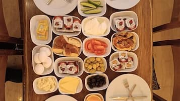 Un buffet de petit-déjeuner avec divers aliments et ustensiles disposés sur une table en bois.