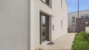 En moderne bygning med en flad facade, en stor glasdør og et lille vindue.