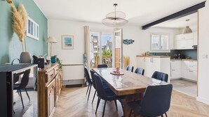 Eine moderne Küche mit weißen Schränken, einem Holzespeisetisch und Stühlen.