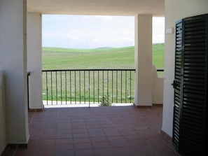 A balcony with a view of a green field and distant power lines. - Beachfront Apartments with Pools, Gardens & Parking in Puerto Zahara (Zahara de los Atunes)