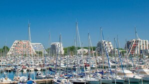 A marina with numerous boats docked, surrounded by modern buildings. - Air-conditioned apartment in city center - 2 guests (La Grande-Motte)